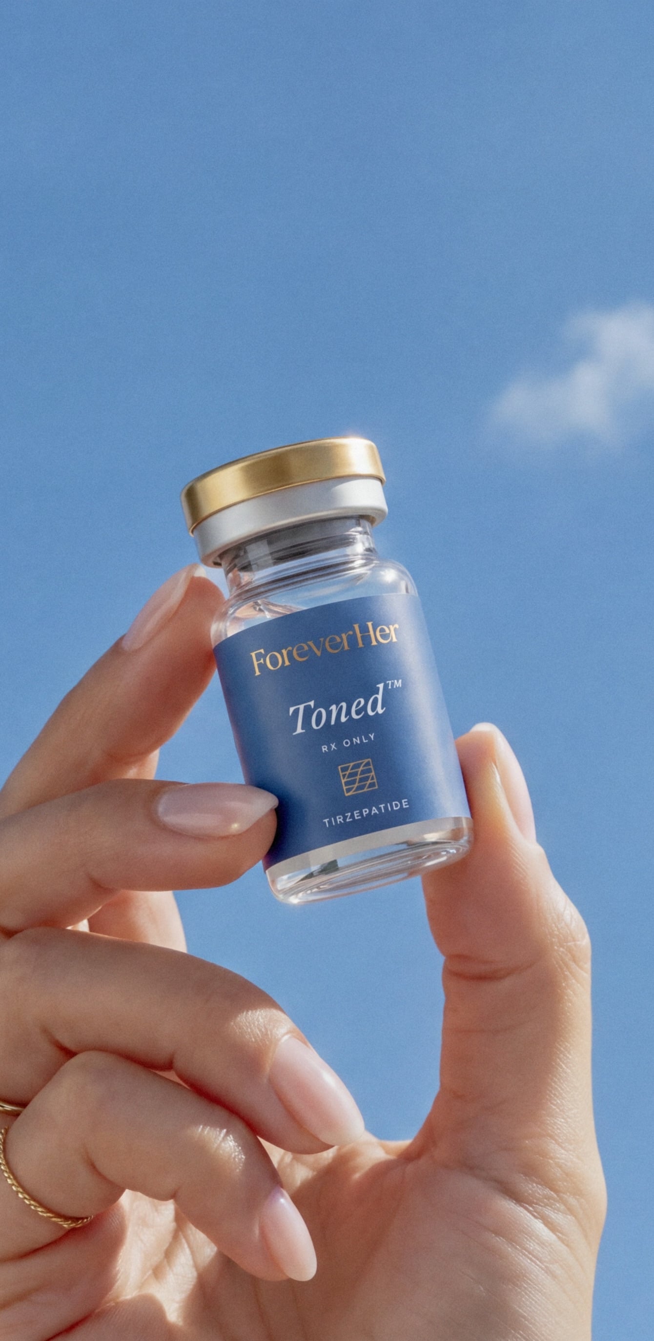A hand holding a Toned vial against a blue sky